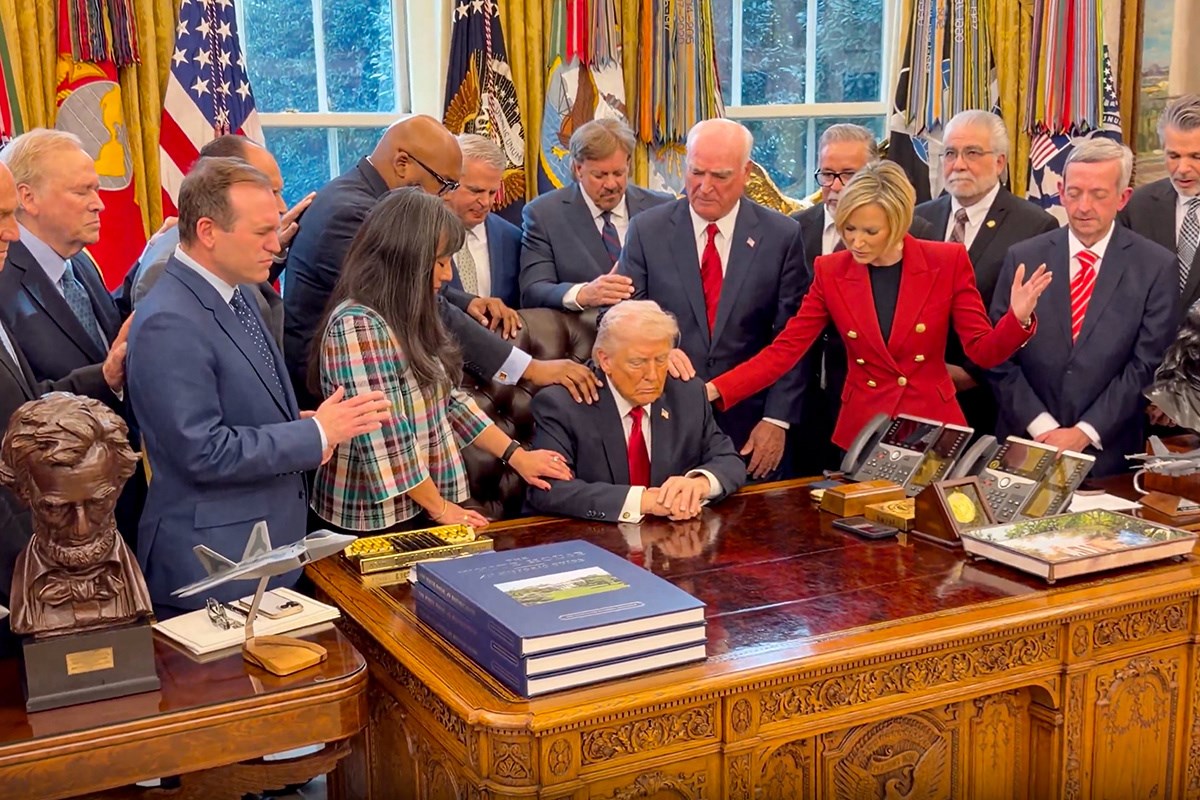 Ovo je snimka iz Bijele kuće. Vjerske vođe drže ruke na Trumpu i mole za njega