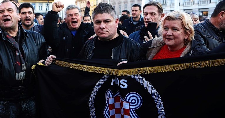 Bujanec na prosvjedu protiv covid-potvrda sa zastavom HOS-a