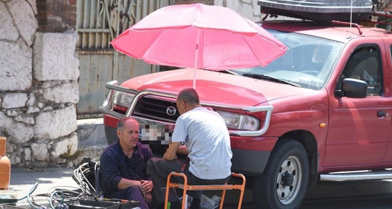 Radnici u Šibeniku stavili suncobran na auto kako bi radili u hladu, prizor je hit