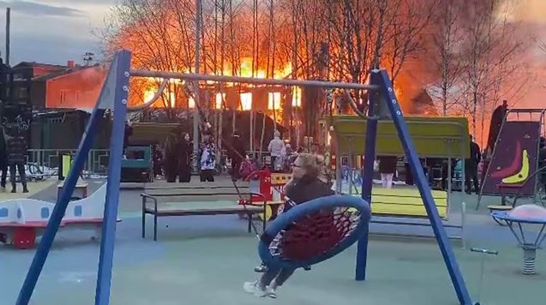 Nadrealna snimka: Ruskinja se opušteno ljuljala u parku dok je požar gutao zgradu