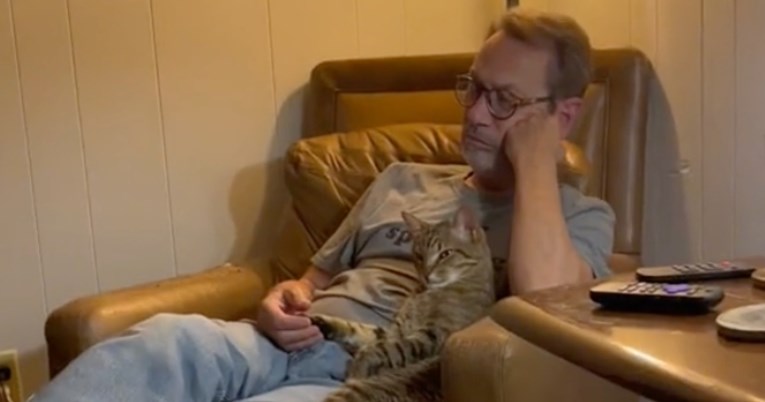 Mačka koja drži vlasnika za ruku dok gleda Sluškinjinu priču topi srca