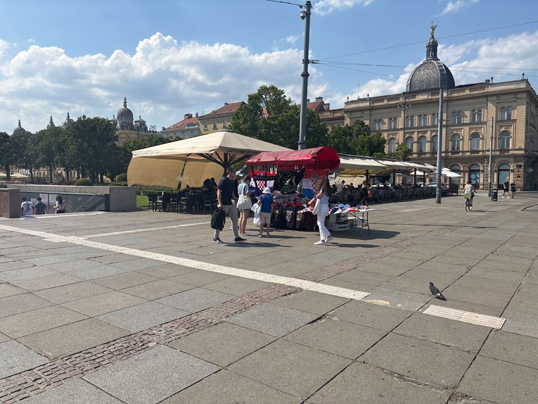 Kod Glavnog kolodvora u Zagrebu štandovi sa zastavama, ljudi kupuju