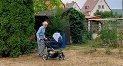 Pradjed vozi bebu u kolicima kako bi se njegova unuka odmorila, prizor topi srca