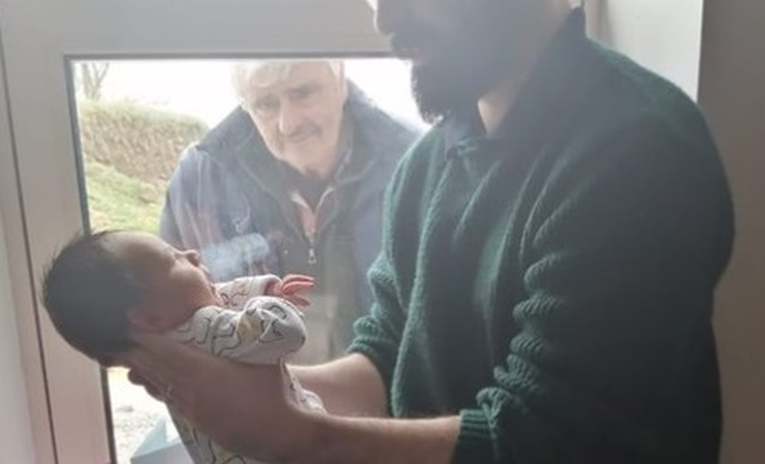Fotka koja lomi srce: Djed zbog koronavirusa upoznao tek rođenog unuka preko prozora