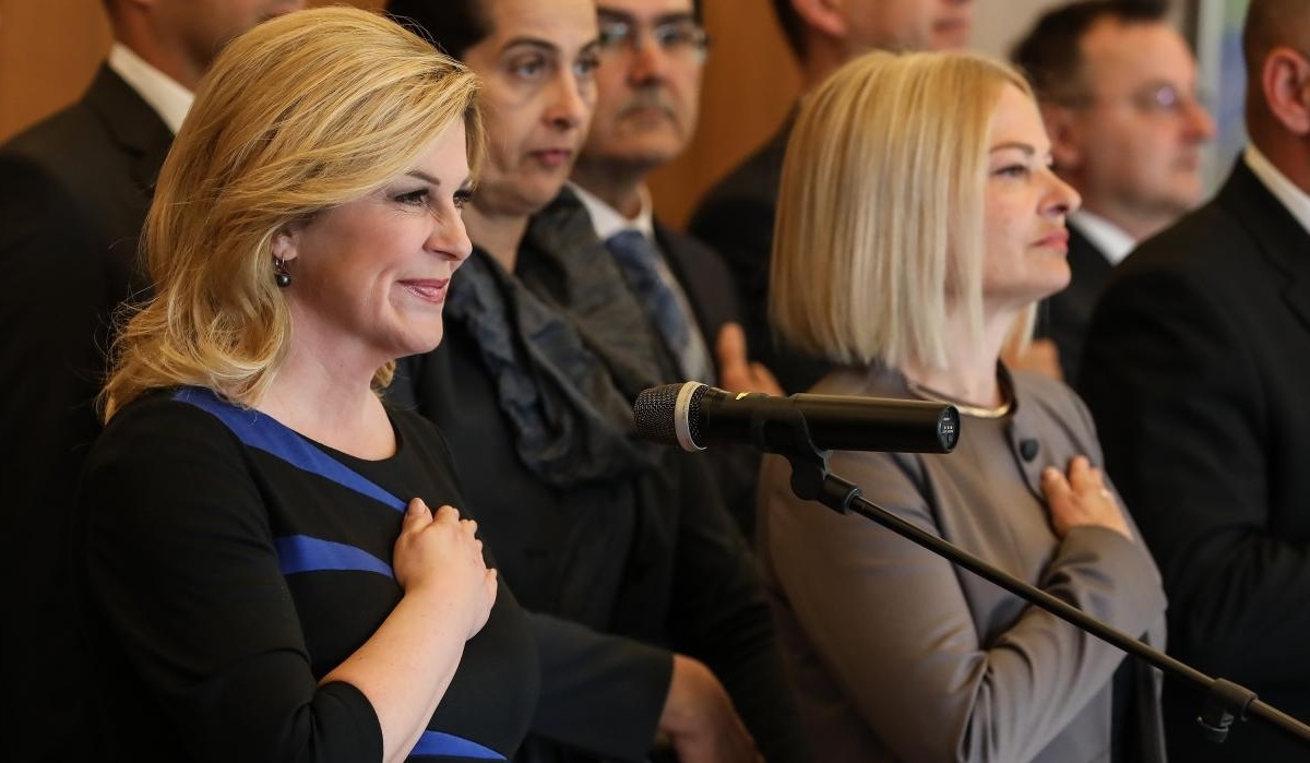 Kolinda blistala u uskoj haljini s prugama i štiklama s visokom potpeticom