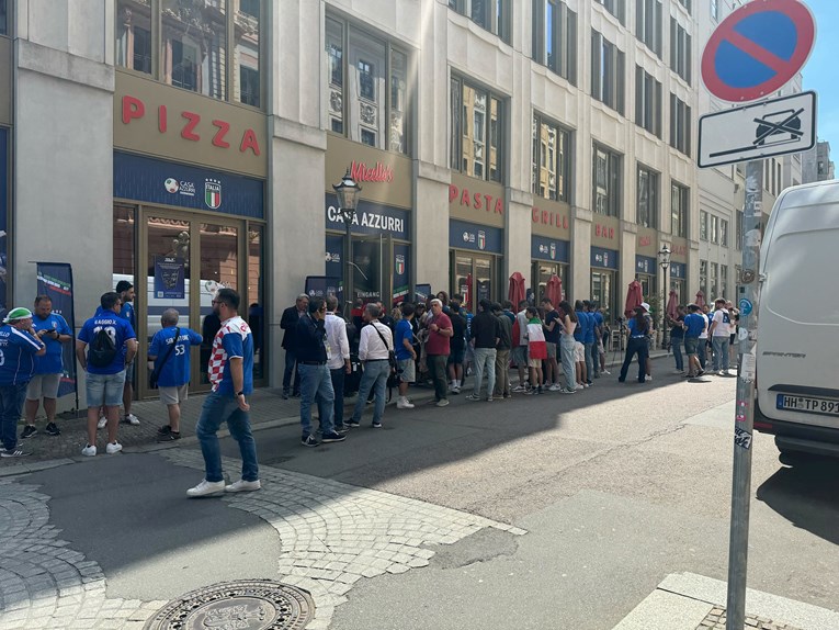Talijanski navijači u Leipzigu u redu ispred natpisa "pizza" i "pasta"