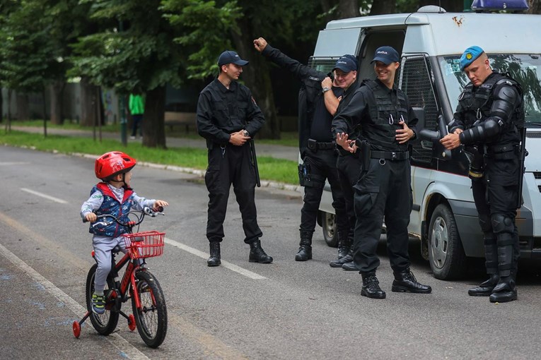 Fotka dana: Dok čekaju Pride, policajci u Sarajevu pozdravili dječaka na biciklu