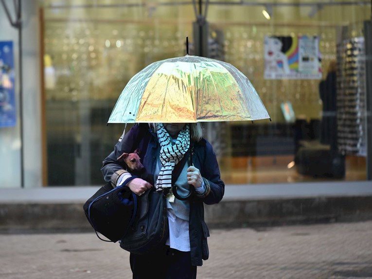 Vlasnica zaštitila svog psića od kiše u Zagrebu, nosila ga u ruci pod kišobranom