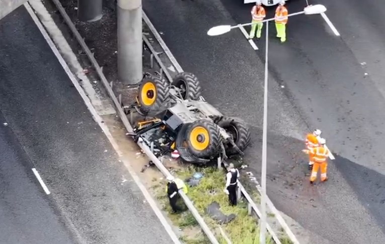 Traktor se sudario s kamionom i pao s mosta na autocestu u Engleskoj. Vozač ozlijeđen