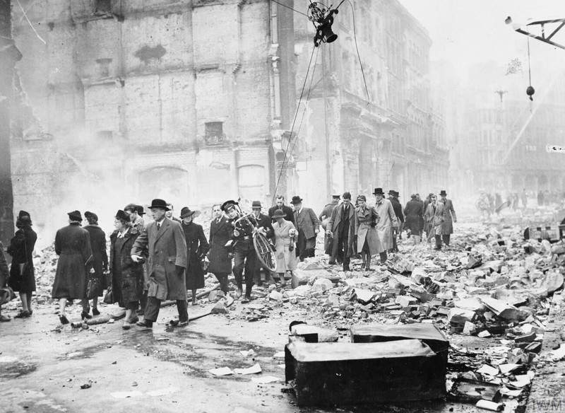 Radnici idu na posao kroz ruševine. Bio je to svakodnevni prizor u Londonu 1940. godine. Bombardiranje je bilo svakodnevno pa se ostatke razrušenih zgrada nije stizalo ukloniti.