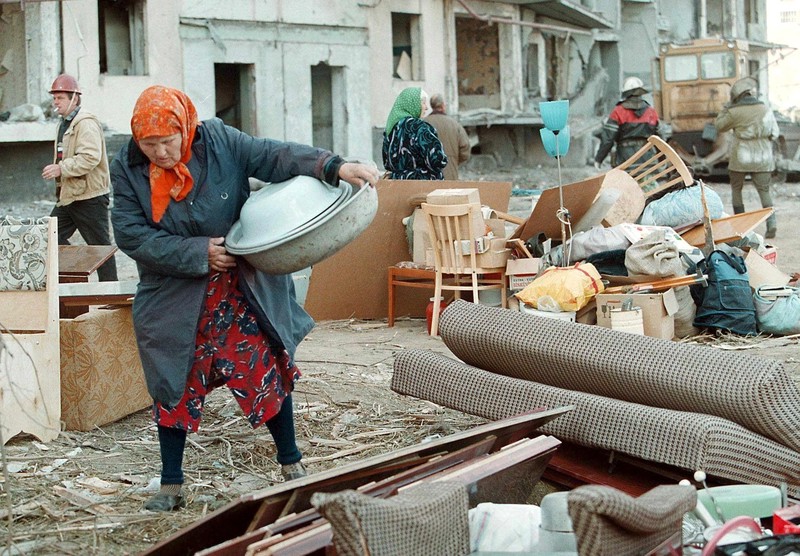 Na ovoj slici vidi se žena kraj stvari spašenih iz uništene zgrade.