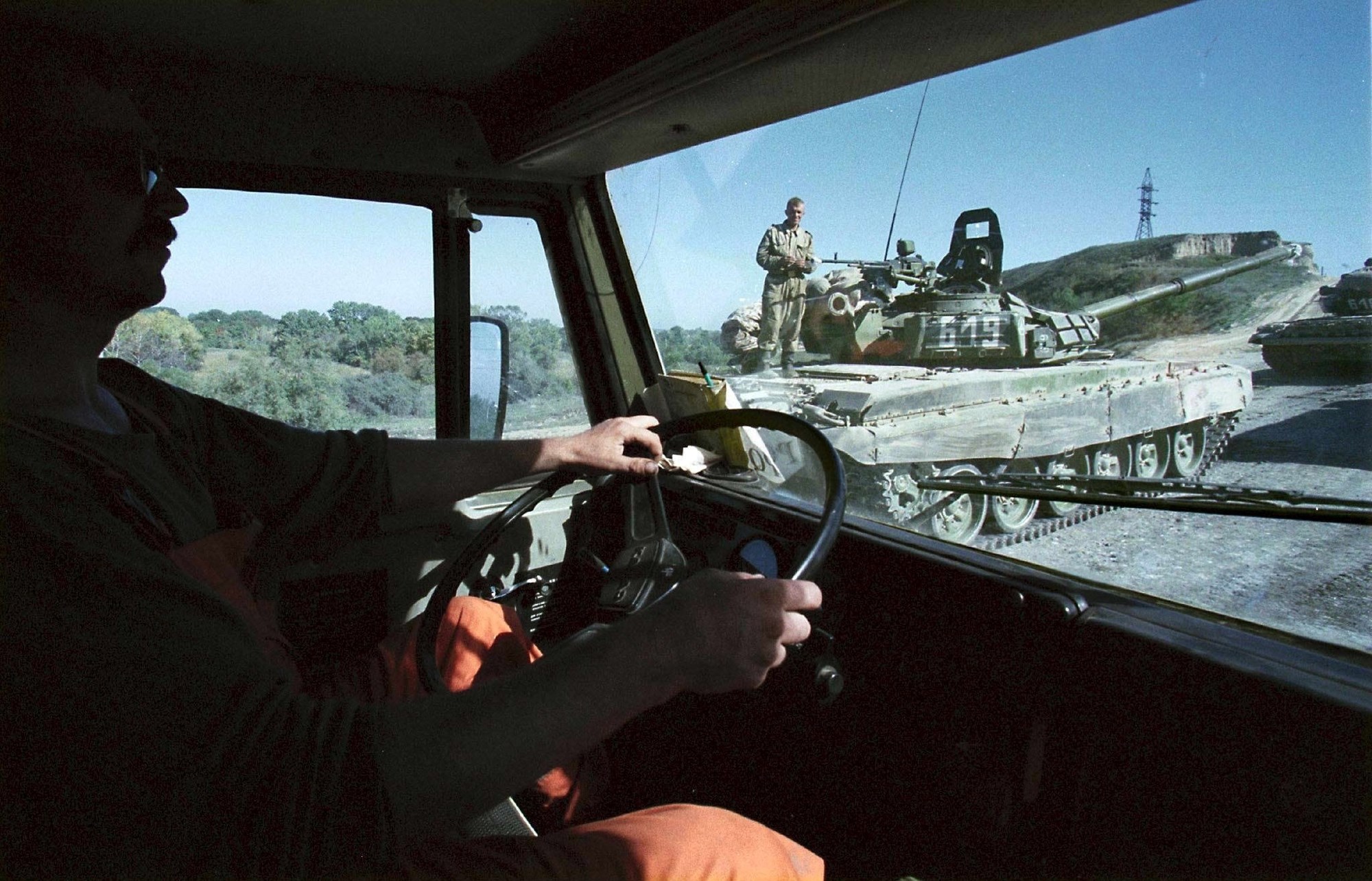 A brz odgovor navodnim teroristima uslijedio je već krajem rujna. Na slici je vozač koji prolazi kolonu tenkova koji idu prema Čečeniji. Slika je nastala 3.10.1999. godine