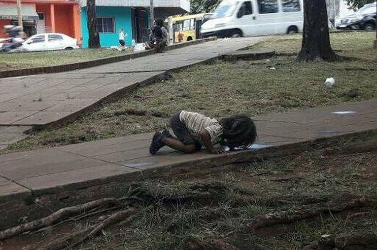 Siromašna djevojčica pije vodu iz male lokvice na tlu, ova fotografija posramila je Argentinu