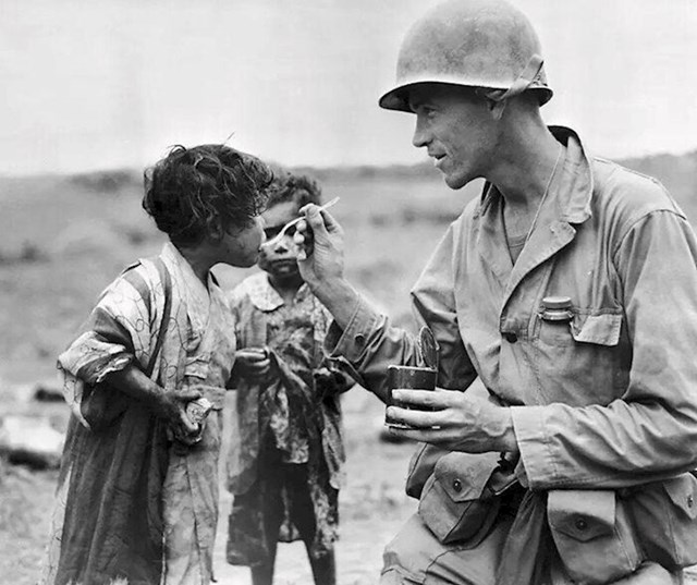 Američki vojnik dijeli svoj obrok s dvoje japanske djece u Okinawi, 1945.