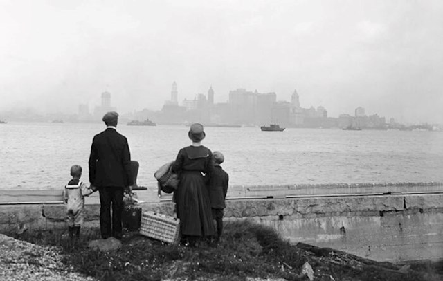 Imigrantska obitelj na pristaništu na otoku Ellis nakon što je upravo položila stroge provjere za ulazak u zemlju, s nadom gleda u horizont New Yorka dok čeka vladin trajekt 13. kolovoza 1925.
