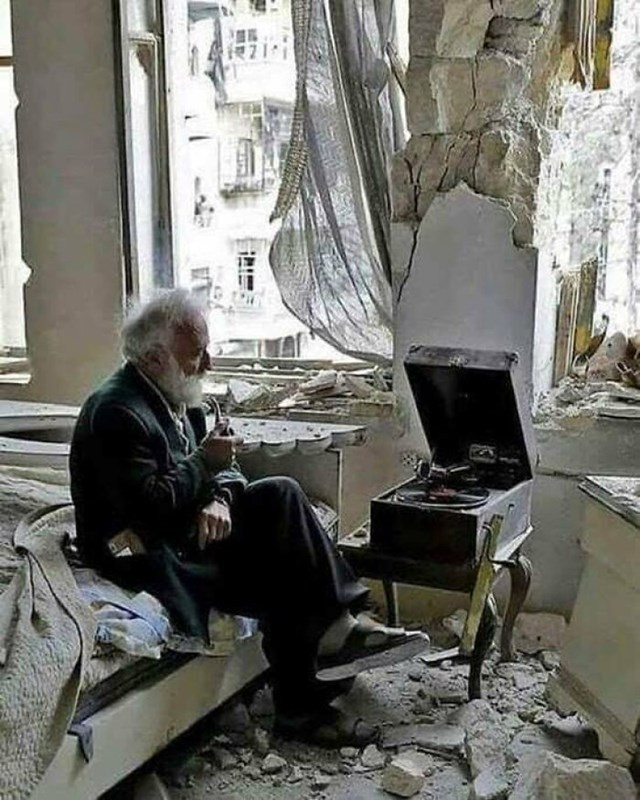 Čovjek sluša gramofon u svojoj uništenoj spavaćoj sobi u Alepu, Sirija. 2017. Autor: Joseph Eid