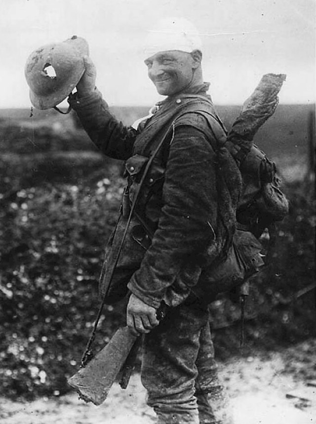Sretni britanski vojnik smiješi se dok pokazuje svoju oštećenu kacigu, 1917.