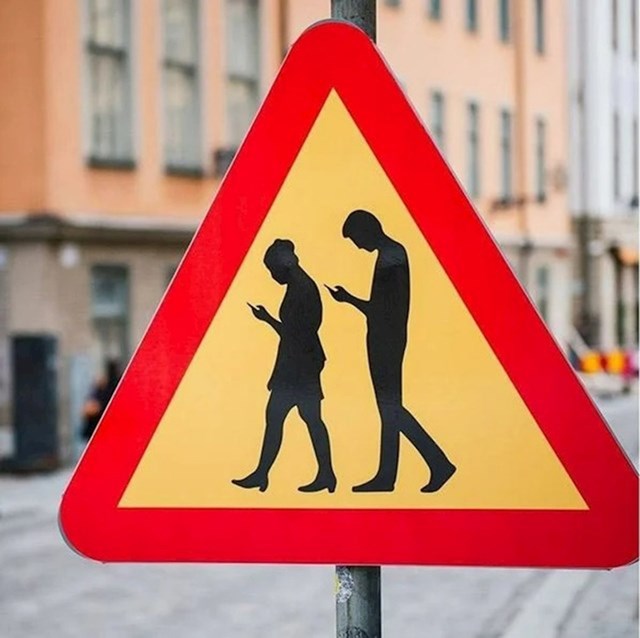Prometni znak koji vozače upozorava na neoprezne pješake na mobilnim telefonima