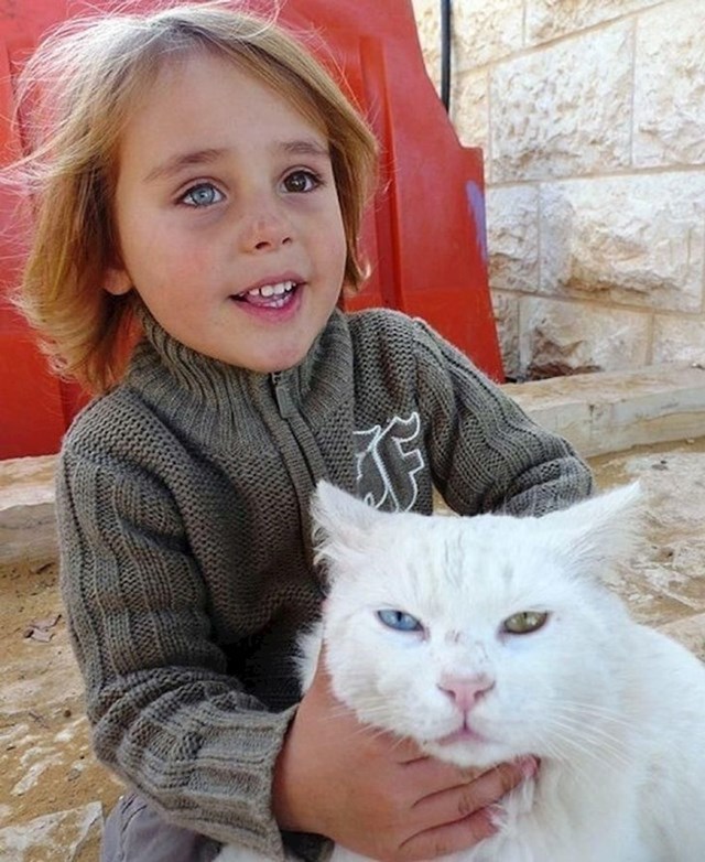 Djevojčica i njena maca s identičnim raznobojnim očima.