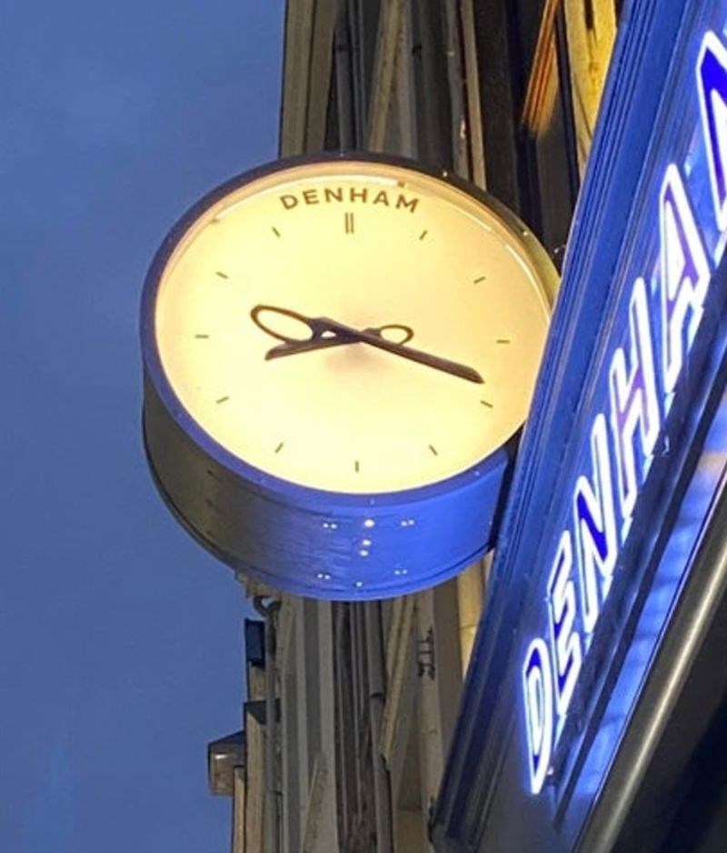 Izgled sata ispred jednog frizerskog salona. Kazaljke izgledaju kao škare.