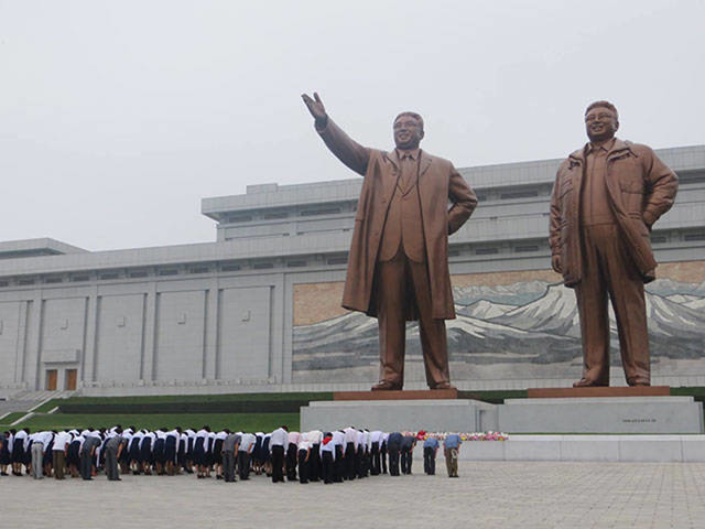 Odavanje počasti kipovima Kim Il-Sunga i Kim Jong-Ila na brdu Munsudae