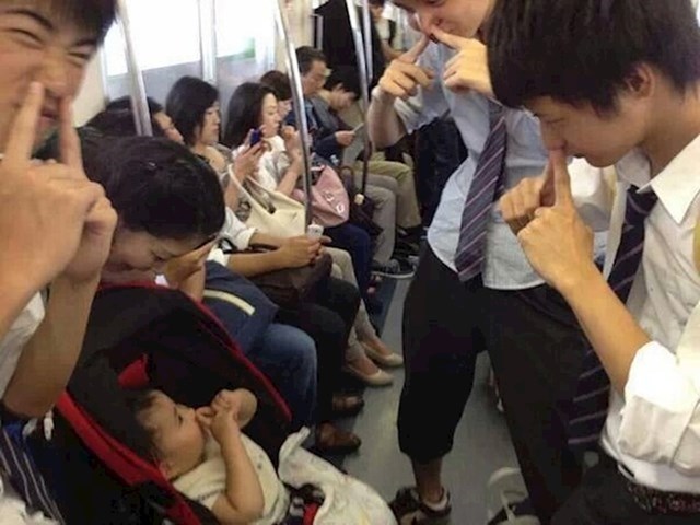 13. Školarci iz Japana zabavljaju uplakanu bebu u podzemnoj željeznici.