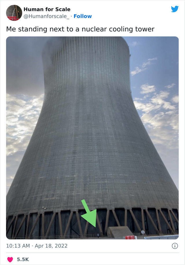 17. Osoba stoji ispred golemog nuklearnog tornja za hlađenje