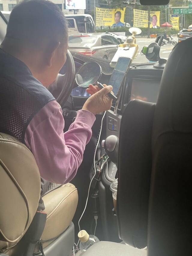 17. Taksist povećalom prati navigaciju na mobitelu