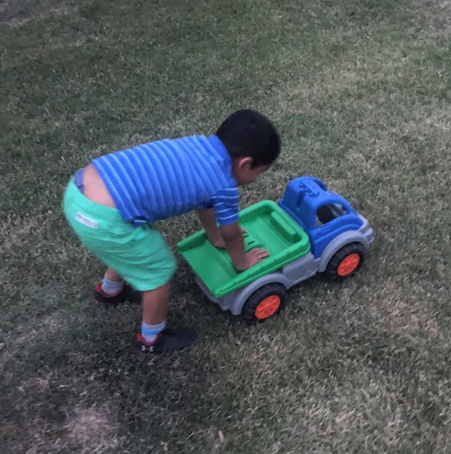 Dječak i kamion u identičnoj kombinaciji boja. Čak i tenisice imaju iste boje kao gume!