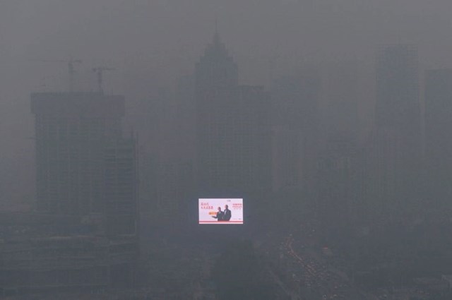 Bliješteća reklama jedino je što se vidi kroz gusti smog u jednom kineskom gradu