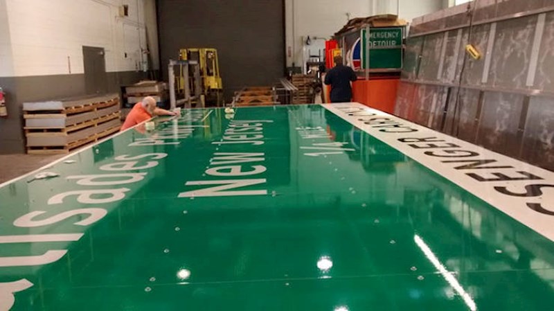 3. Radnik pored prometnog znaka koji će se postaviti na autocestu