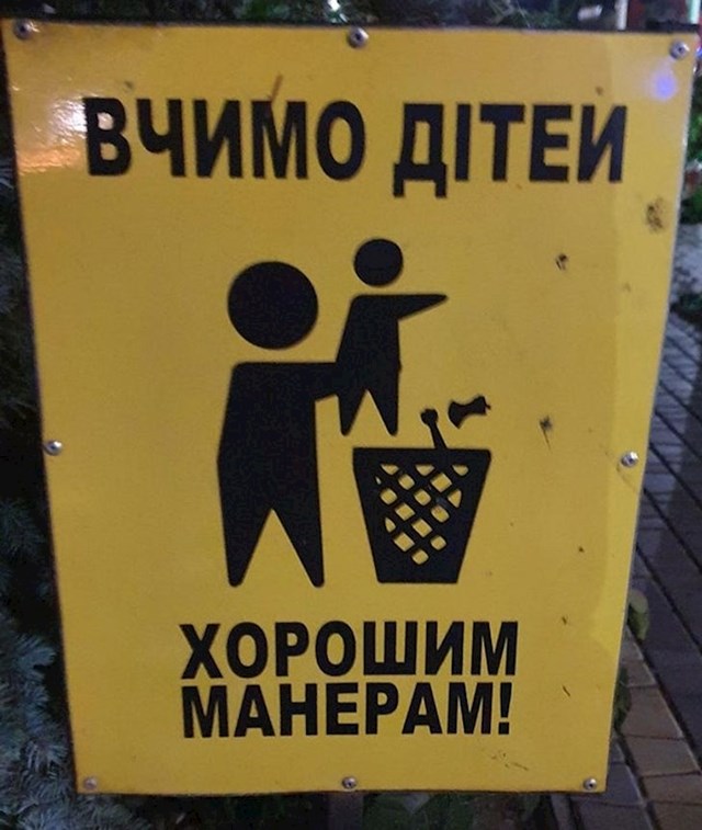 Znak poručuje da se djecu uči da ne bacaju otpatke po ulici, ali izgleda kao da čovjek baca dijete u kantu za smeće