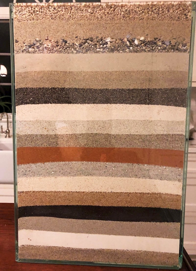 Osoba u staklenom spremniku čuva slojeve pijeska sa svih plaža na kojima je bila u zadnjih nekoliko godina...