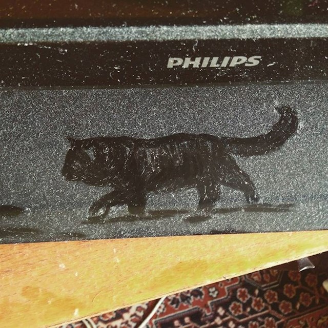 Netko je na prašini nacrtao mačku.