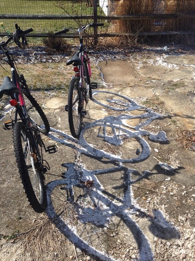 tanki sloj snijega preživio je u sjeni bicikla...