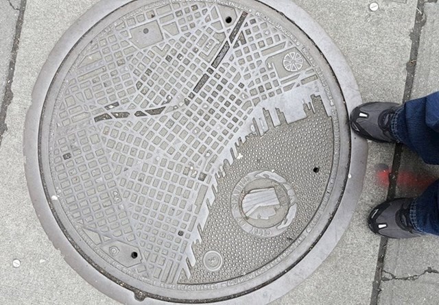 Ovi poklopci za kanalizacijski šaht na sebi imaju kartu grada (Seattle, SAD).
