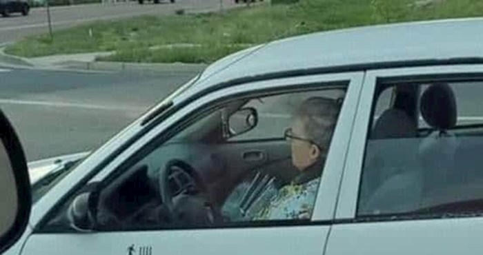 Ova starija žena na vratima svog auta ima naljepnice koje bi prolaznike mogle zabrinuti