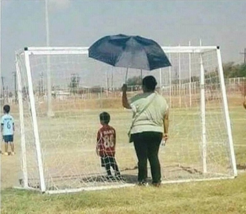 Ova mama štiti sina od sunca tijekom utakmice.