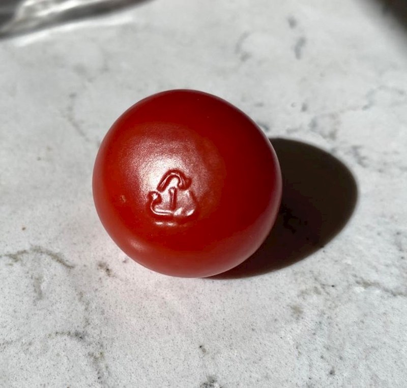 Rajčica na kojoj se slučajno otisnuo znak recikliranja s ambalaže.