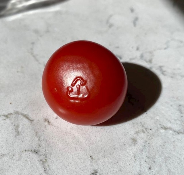 Rajčica na kojoj se slučajno otisnuo znak recikliranja s ambalaže.