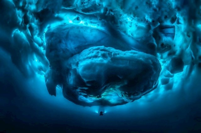 Ronioc koji roni ispod golemog podvodnog dijela sante leda.
