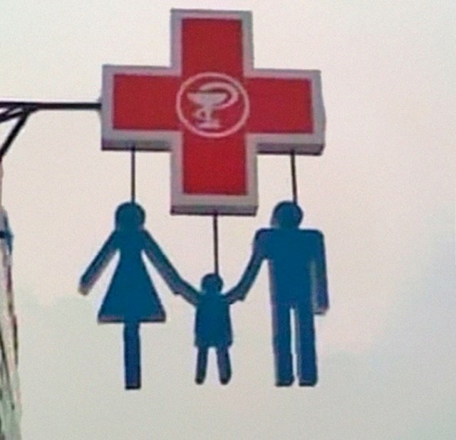 2. Obitelj koja visi sa znaka za ljekarnu.