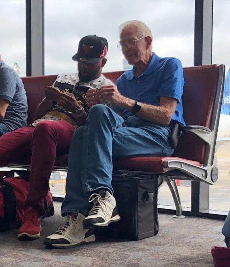 13. Stariji čovjek uči mlađeg osnove origamija pomoću novčanice dolara