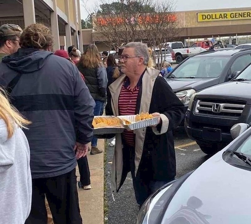 17. Čovjek dijeli hranu iz svojeg restorana ljudima koji čekaju u redu.