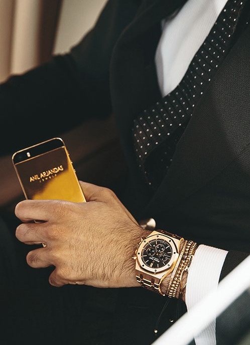 Golden Audemars Piguet watch and Anil Arjandas accesories.