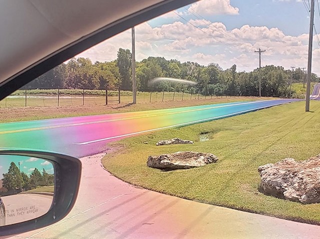 Slikano kroz polarizirane leće, cesta izgleda kao da je prekrivena bojama