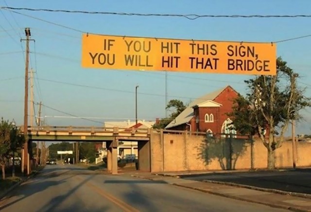 Znak koji upozorava kamione da će, ako njega dotaknu, zapeti za onaj most naprijed