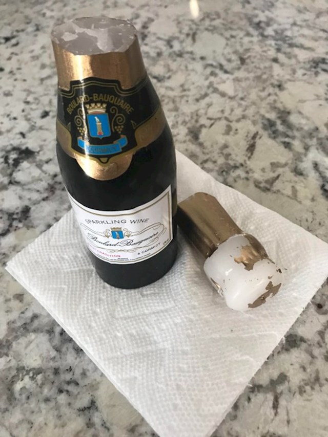 Supruga je dobila poklon od firme u kojem su bili slatkiši, cvijeće i ova mala boca šampanjca koju smo spremili u hladnjak do večeras kad smo slavili godišnjicu i shvatili da je to ustvari svijeća