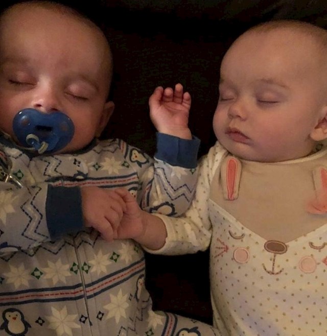Moji blizanci se drže za ruke dok spavaju
