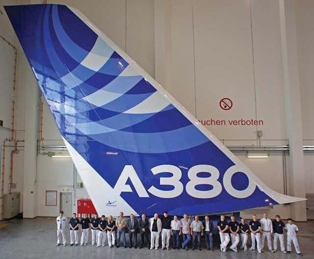 Radnici stoje ispred repa aviona Airbus A380